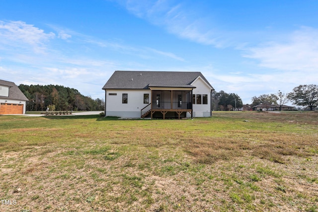 back of property featuring a sunroom and a yard