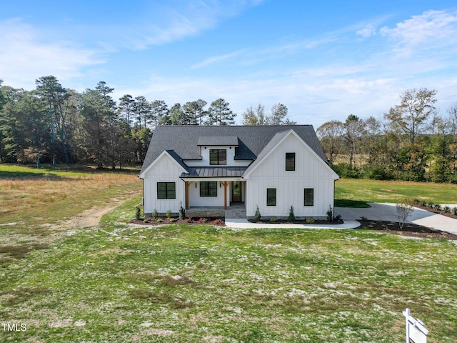 modern farmhouse style home with a front yard and covered porch