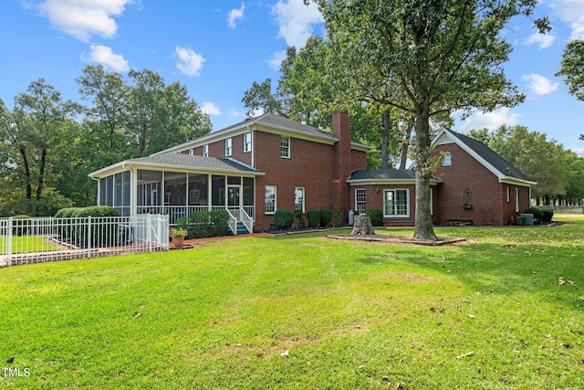 back of property with a sunroom and a lawn