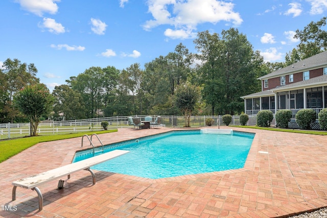 view of pool with a patio, a diving board, and a sunroom