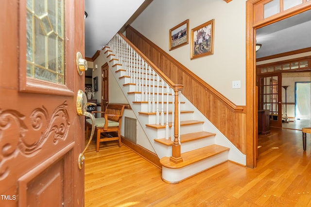 staircase featuring crown molding and hardwood / wood-style floors