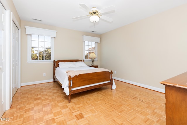 bedroom with ceiling fan, light parquet flooring, and multiple windows