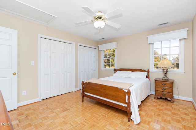 bedroom with ceiling fan, light parquet flooring, and multiple windows