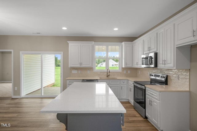 kitchen with a wealth of natural light, white cabinetry, and appliances with stainless steel finishes