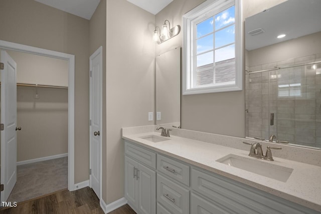 bathroom with hardwood / wood-style flooring, vanity, and a shower with shower door