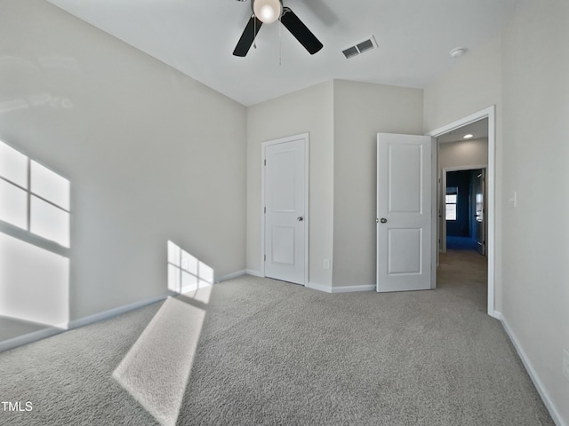 unfurnished bedroom with ceiling fan and light colored carpet