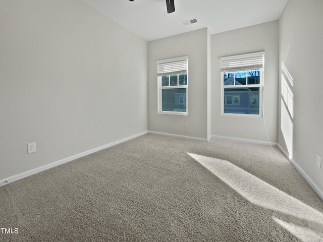 carpeted spare room with ceiling fan