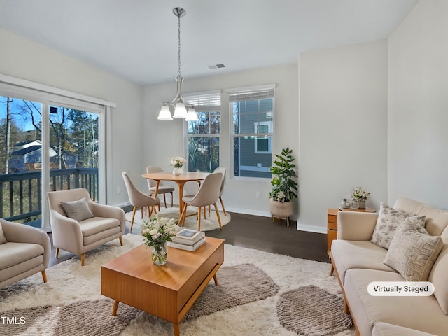 living room featuring wood-type flooring and a notable chandelier