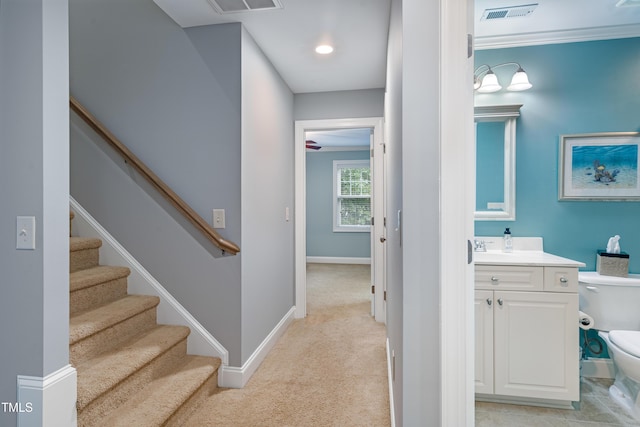 hall with light colored carpet, stairway, and baseboards