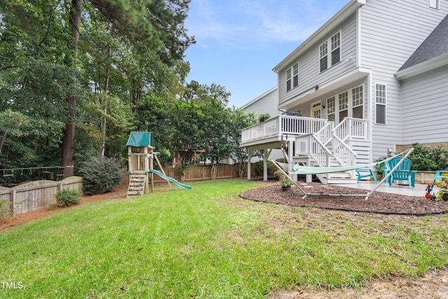 view of yard featuring a playground, stairs, a wooden deck, and a patio area