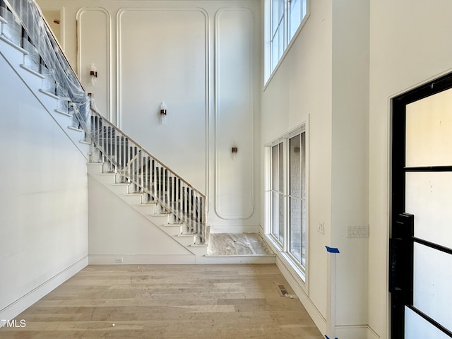 foyer entrance with a high ceiling and light wood-type flooring