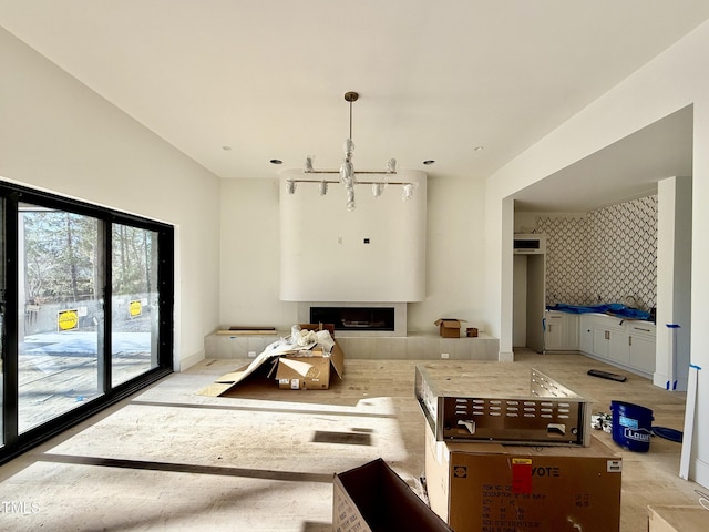 living room with an inviting chandelier, a fireplace, and track lighting