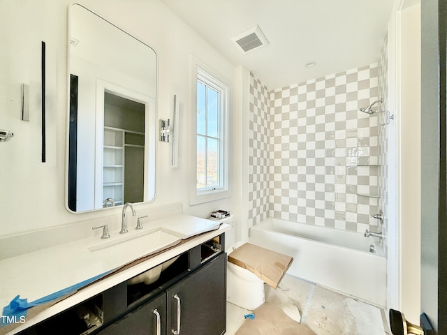 bathroom featuring tiled shower / bath and vanity