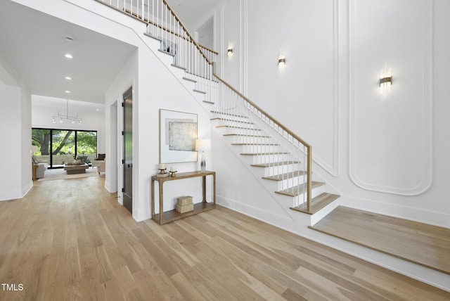 712 Daniels St, Raleigh, NC 27605 - interior space featuring recessed lighting, wood finished floors, baseboards, stairs, and a notable chandelier