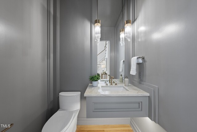 712 Daniels St, Raleigh, NC 27605 - bathroom with toilet, wood finished floors, and vanity