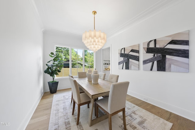 712 Daniels St, Raleigh, NC 27605 - dining space featuring light wood-type flooring, baseboards, a chandelier, and ornamental molding