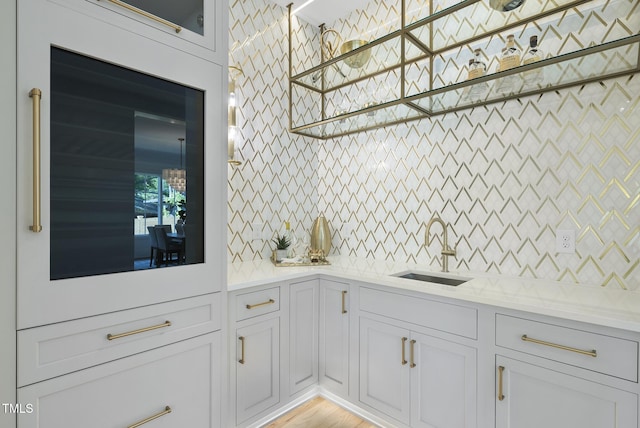 712 Daniels St, Raleigh, NC 27605 - kitchen with backsplash, white cabinets, glass insert cabinets, and a sink