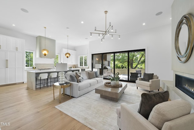 712 Daniels St, Raleigh, NC 27605 - living room with a healthy amount of sunlight, light wood-type flooring, recessed lighting, and a tiled fireplace