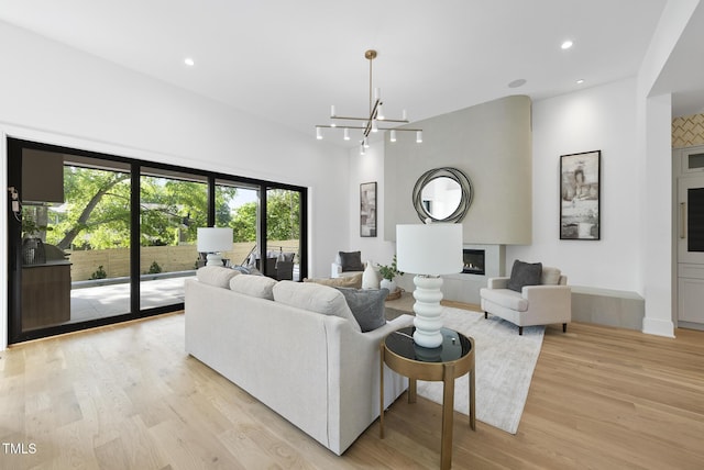 712 Daniels St, Raleigh, NC 27605 - living area with an inviting chandelier, light wood-style flooring, a fireplace, and recessed lighting