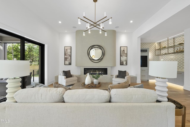 712 Daniels St, Raleigh, NC 27605 - living room with a fireplace, wood finished floors, recessed lighting, and an inviting chandelier