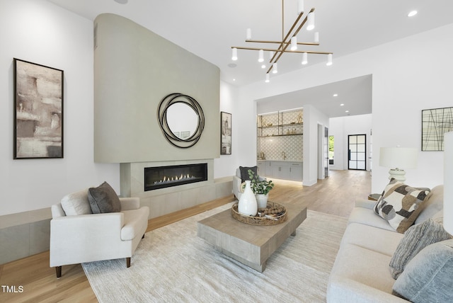 712 Daniels St, Raleigh, NC 27605 - living room with light wood finished floors, a tile fireplace, recessed lighting, and a chandelier