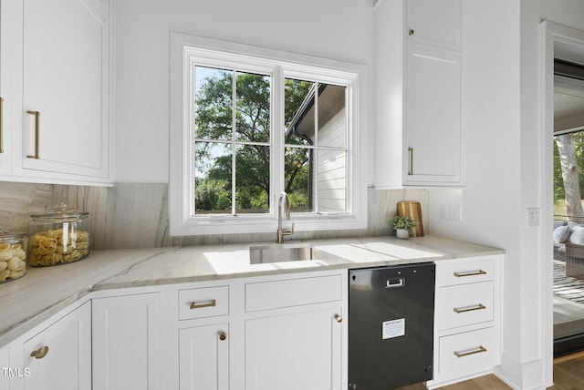 712 Daniels St, Raleigh, NC 27605 - kitchen featuring light stone countertops, white cabinets, and a sink