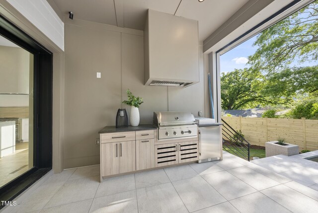712 Daniels St, Raleigh, NC 27605 - interior space featuring refrigerator, modern cabinets, light tile patterned flooring, and custom range hood