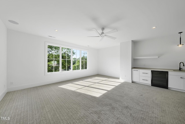 712 Daniels St, Raleigh, NC 27605 - unfurnished living room with beverage cooler, wet bar, a sink, light colored carpet, and ceiling fan