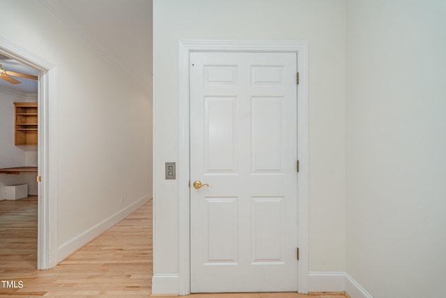 hall featuring crown molding and light hardwood / wood-style floors