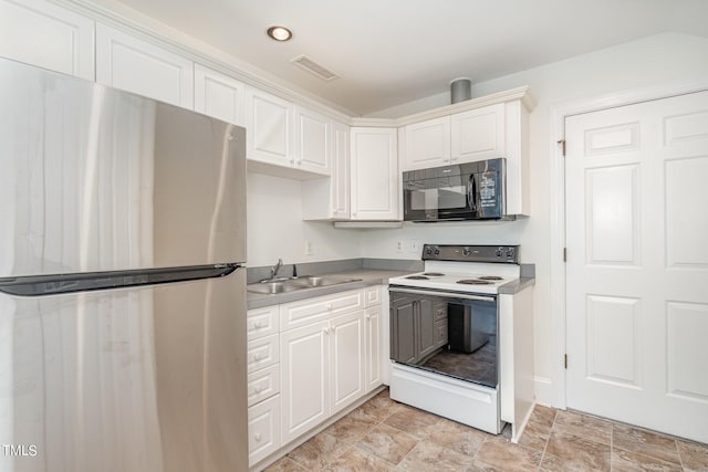 kitchen featuring sink, electric range, white cabinetry, and stainless steel refrigerator