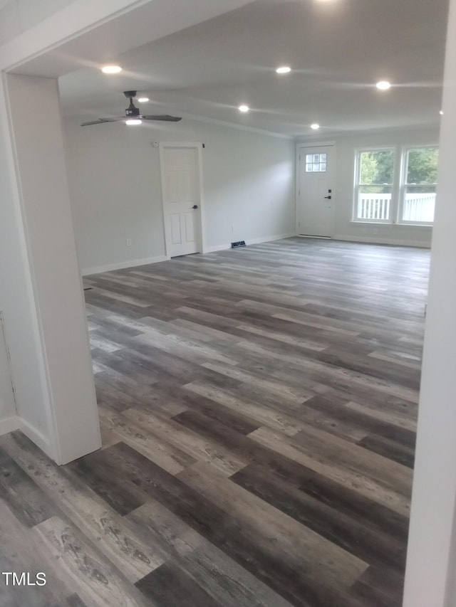 unfurnished room with ceiling fan and dark wood-type flooring