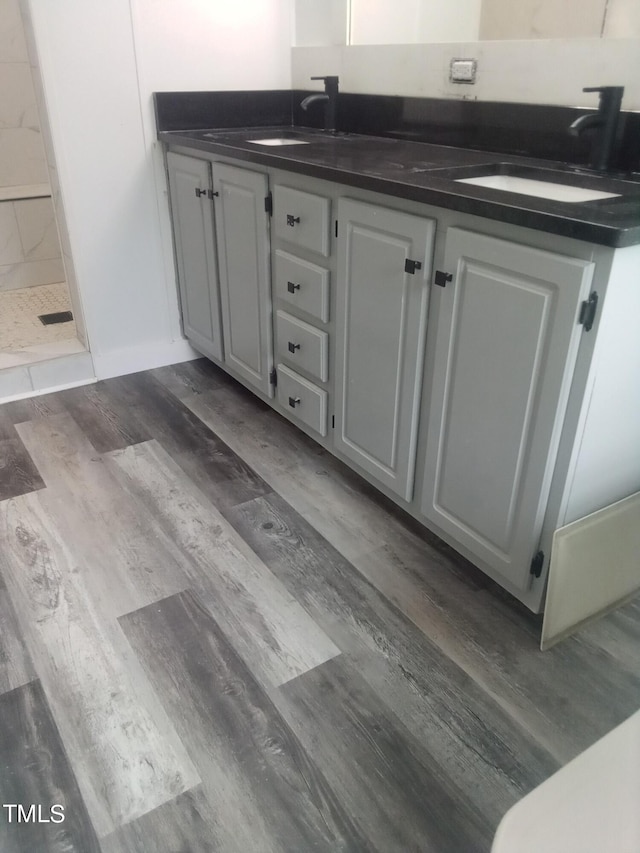 interior space featuring walk in shower, vanity, and hardwood / wood-style floors