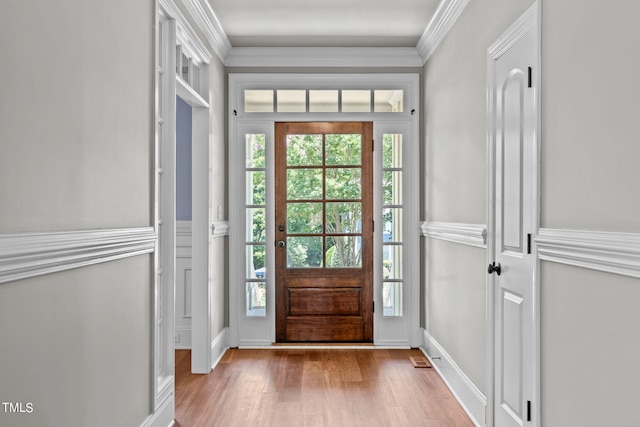 doorway with light hardwood / wood-style flooring and crown molding