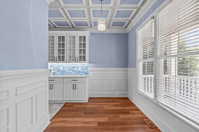 interior space featuring decorative backsplash, white cabinetry, hanging light fixtures, and dark hardwood / wood-style flooring