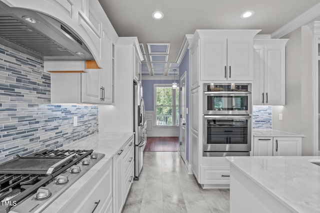 kitchen featuring light stone counters, white cabinets, stainless steel appliances, and range hood