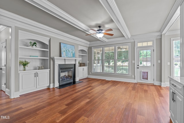 unfurnished living room featuring hardwood / wood-style flooring, built in features, and crown molding