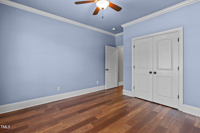 unfurnished bedroom with ornamental molding, dark wood-type flooring, ceiling fan, and a closet