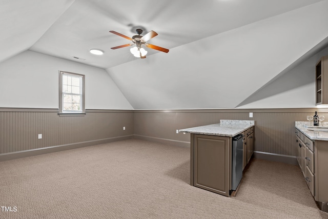 bonus room with ceiling fan, sink, wooden walls, light colored carpet, and vaulted ceiling