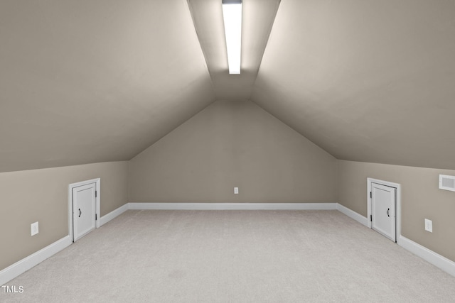 bonus room with vaulted ceiling and light carpet