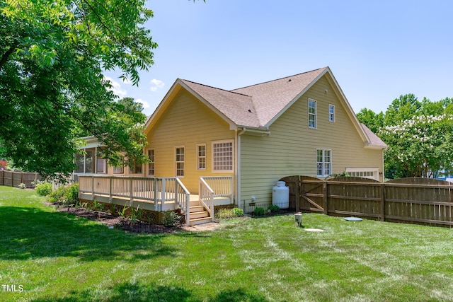 rear view of property with a yard and a wooden deck