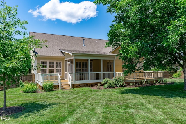 rear view of property with a sunroom, a yard, and a deck