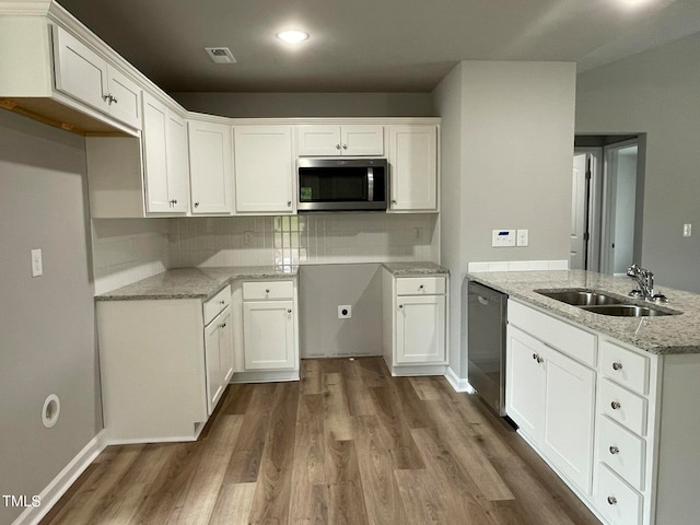 kitchen with sink, white cabinetry, appliances with stainless steel finishes, dark hardwood / wood-style flooring, and light stone countertops