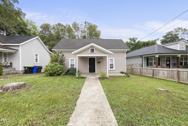 bungalow-style house with fence, a porch, and a front yard