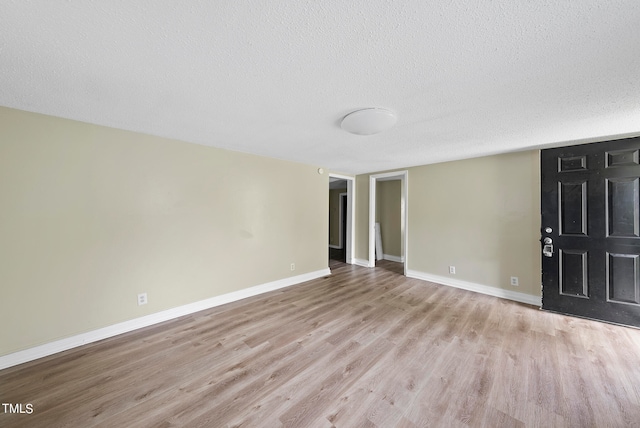 empty room featuring light hardwood / wood-style flooring and a textured ceiling