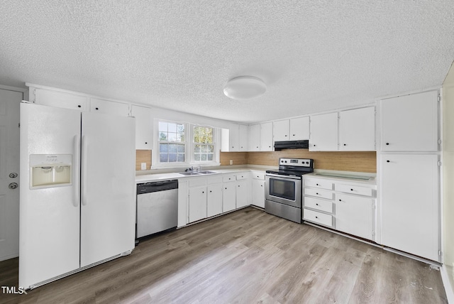 kitchen featuring light wood-style flooring, a textured ceiling, appliances with stainless steel finishes, and a sink