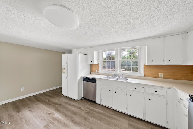 kitchen featuring appliances with stainless steel finishes, white cabinets, a textured ceiling, light hardwood / wood-style flooring, and sink