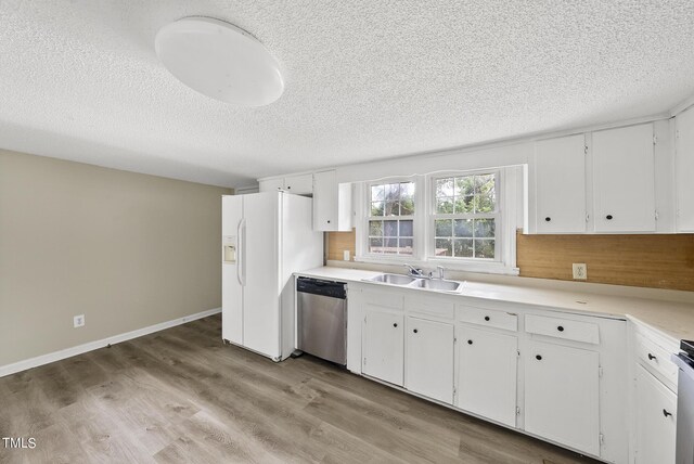 kitchen with a sink, a textured ceiling, white cabinetry, dishwasher, and white fridge with ice dispenser
