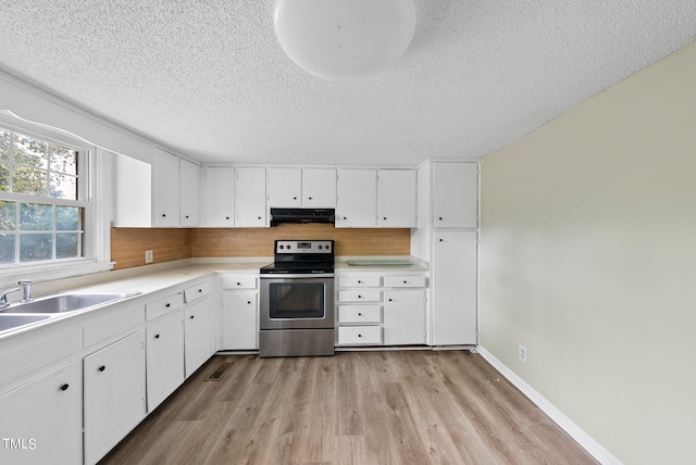 kitchen with light hardwood / wood-style flooring, white cabinets, and stainless steel range with electric stovetop