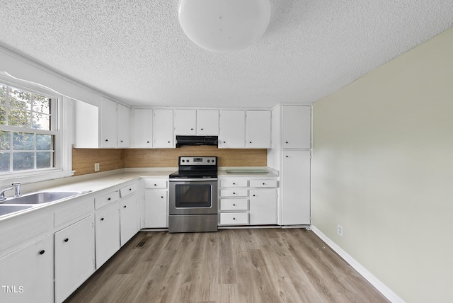kitchen featuring stainless steel electric stove, a textured ceiling, light wood finished floors, and under cabinet range hood
