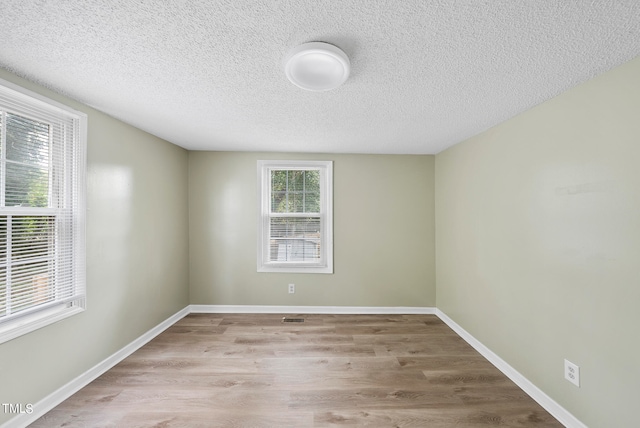 empty room featuring light hardwood / wood-style flooring and a textured ceiling